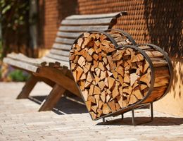 A heart-shaped stack of wood stands next to a wooden bench. The scene has a warm, inviting atmosphere.